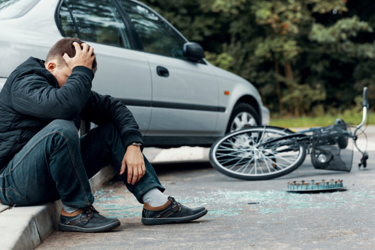 Man holding head after a car accident with bike